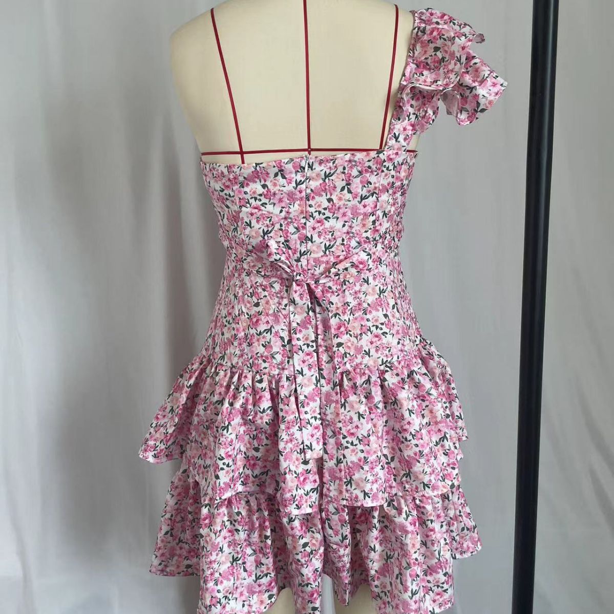 A one-shoulder, flappy, waist-exposed, sexy and fashionable pink lace-up floral dress for a hot girl